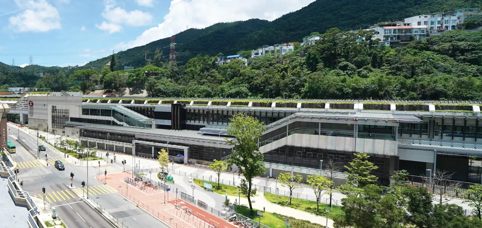 Modern railway station with eco-friendly green roof and urban landscape.