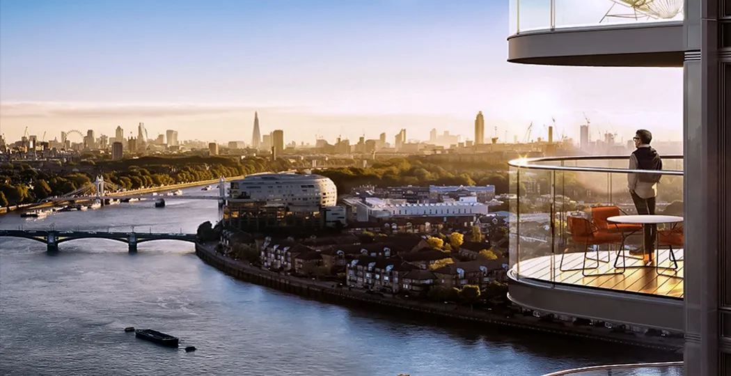 Man enjoying the panoramic view of the River Thames from a modern high-rise balcony with glass balustrade, highlighting the London skyline at sunrise with notable landmarks and construction cranes in the distance