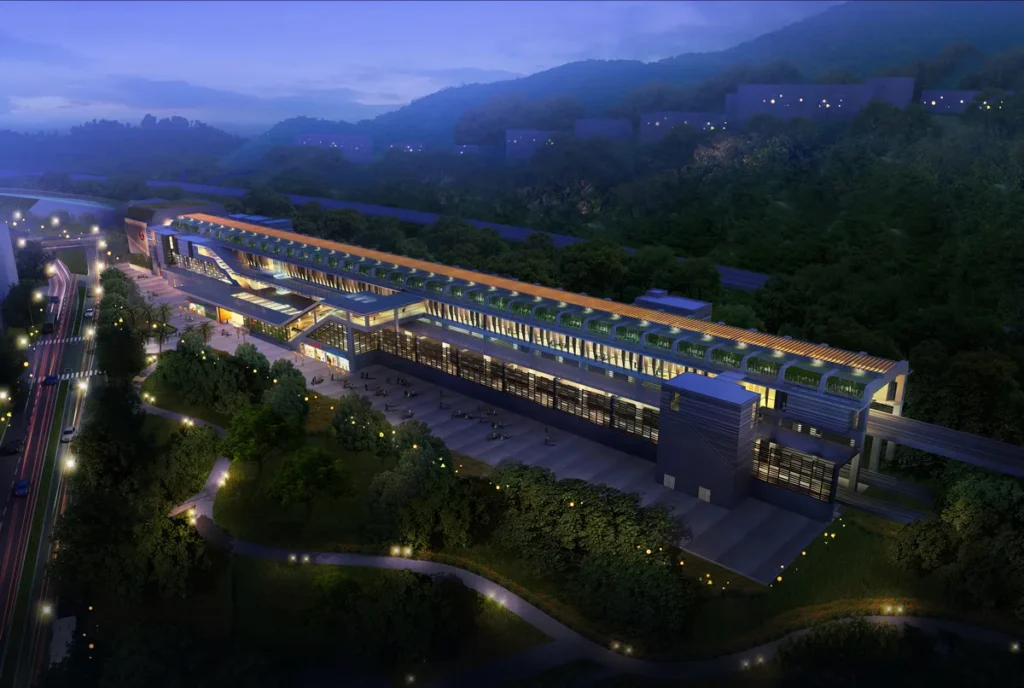 Nighttime view of a train station with illuminated green rooftop gardens.