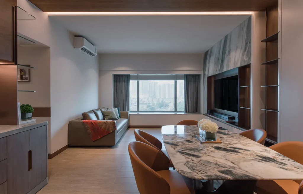 Rebel Arkitekt's design marvel, showcasing a luxurious open-plan living space with panoramic Victoria Harbour views, a sleek marble dining table, and integrated ambient lighting, creating a perfect harmony of style and comfort.