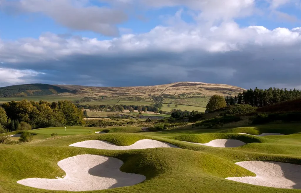 Golf course at Gleneagles with distinctive bunkers and mountain backdrop.