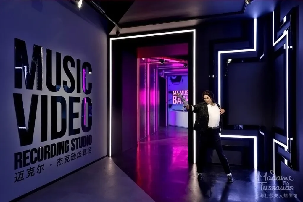 A wax figure of Michael Jackson in a dance pose at Madame Tussauds Hong Kong's Music Video Recording Studio section with neon lights and stylish decor.