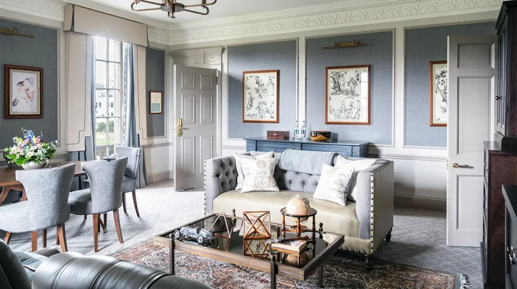 Elegant suite interior with grey decor, plush seating, and vintage accents.