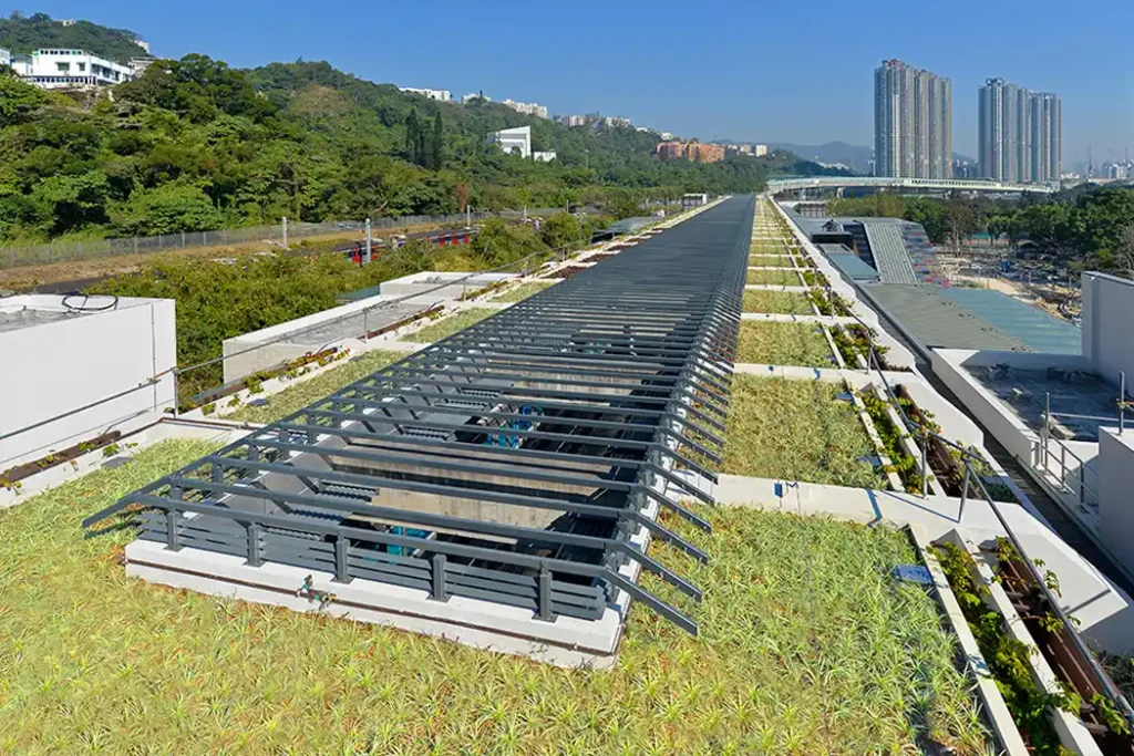 Top view of MTR station with a sustainable green roof in an urban setting.