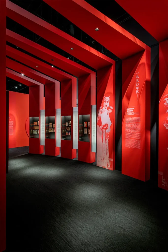 Showcasing the immersive, crimson-hued exhibit featuring dynamic architectural elements that lead visitors through Hong Kong's rich operatic history at the Heritage Museum.