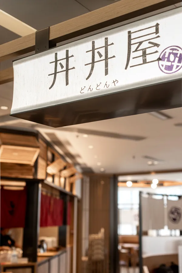 Authentic Japanese signage featuring calligraphy, a distinguished design element by Rebel Arkitekt for the DONDONYA x TORIKAI restaurant entrance.