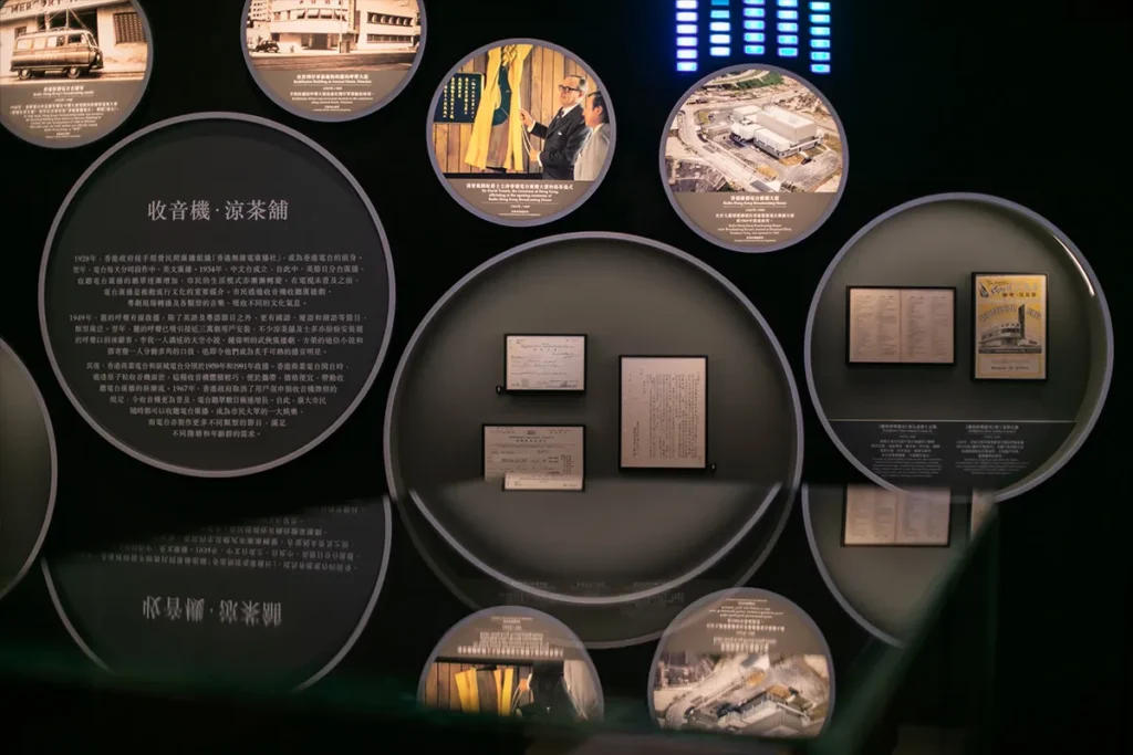 The exhibitmfeatures a collection of Hong Kong's broadcasting memorabilia, presented in an array of circular displays with strategic lighting, highlighting the city's history in media development.