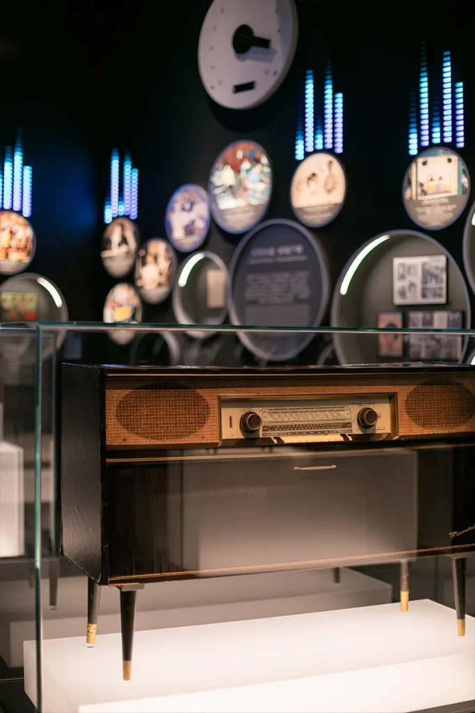 This image captures an elegantly displayed vintage radio within a modern exhibit, reflecting the careful management and presentation of historical media technology, a task overseen by Rebel Arkitekt.