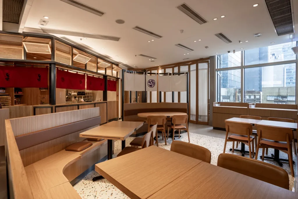 Post-renovation dining space at DONDONYA x TORIKAI, featuring serene wood tones and traditional red accents, a harmonious blend by Rebel Arkitekt.