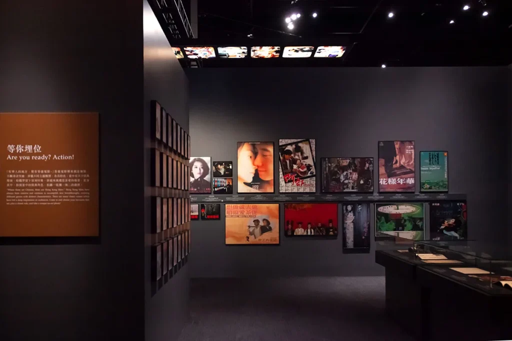 Exhibition space with an array of classic and contemporary Asian film posters contrasted against a dark background.