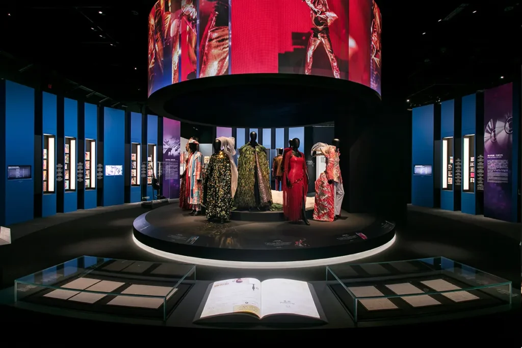 The circular exhibition area presents a vibrant display of theatrical costumes, encircled by informative panels highlighting the dynamic stage presence pivotal to Hong Kong's performing arts, project managed by Rebel Arkitekt to deliver an engaging visitor experience.