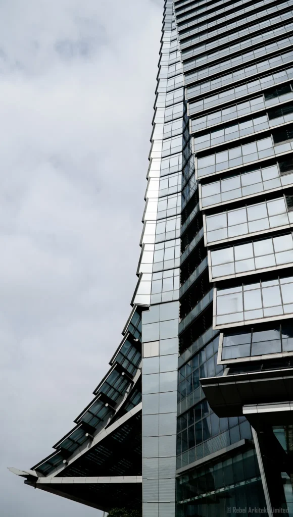 Architectural photography of a modern building with angular lines and reflective glass facade by Rebel-i, Rebel Arkitekt's photography division.