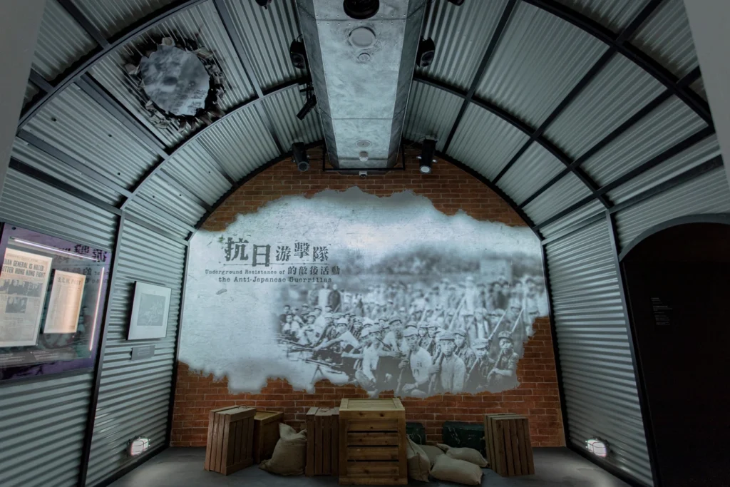 Gallery exhibit at the Hong Kong Museum of Coastal Defence showcasing the Anti-Japanese Guerrillas, with a wall projection and immersive historical artifacts.