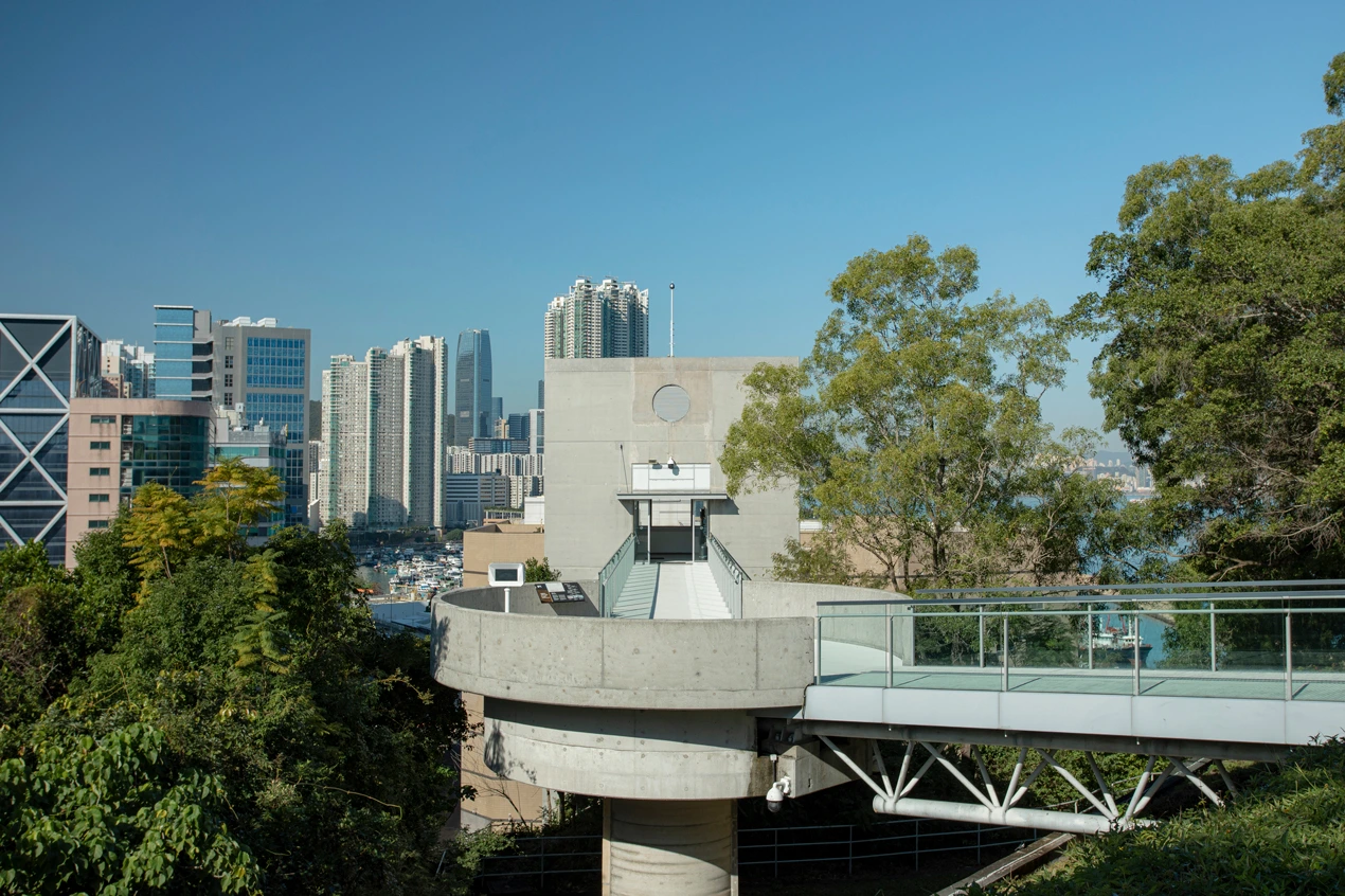 Modern entrance of the Hong Kong Museum of Coastal Defence, with a view of surrounding urban skyscrapers and greenery