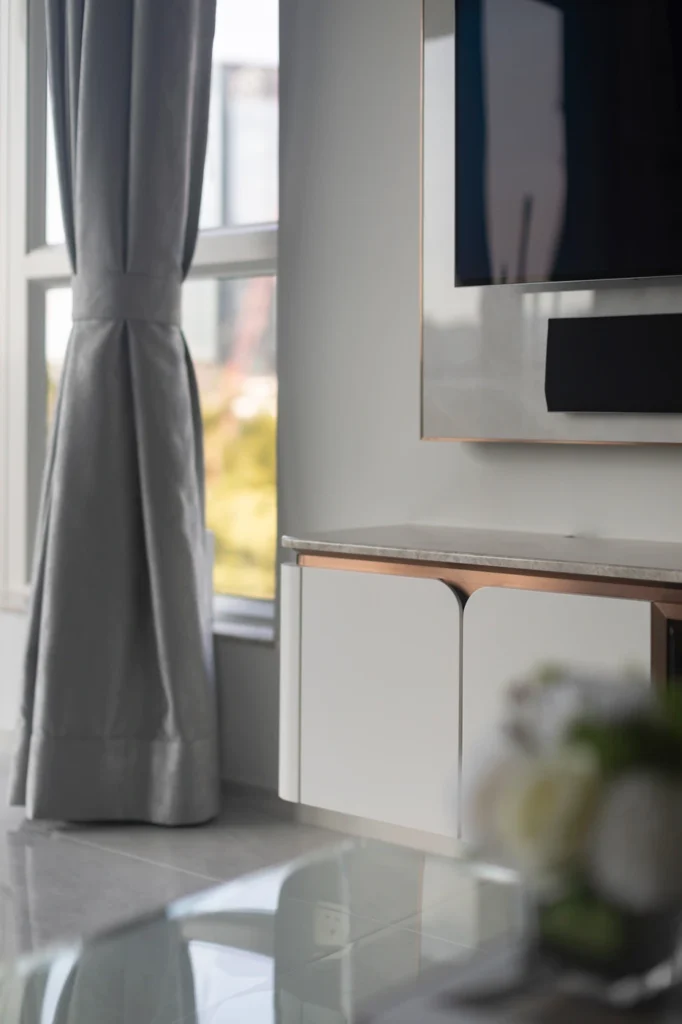 tv mounted above bespoke cabinet with curtains and natural light