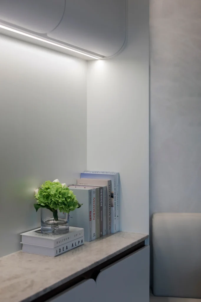 books and floral decor on marble-top cabinet under soft lighting